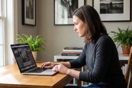Femme en train d'éditer des photos sur un ordinateur dans un bureau lumineux