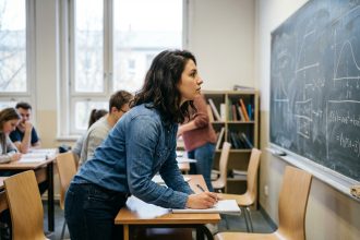 Jeune femme concentrée prenant des notes en classe